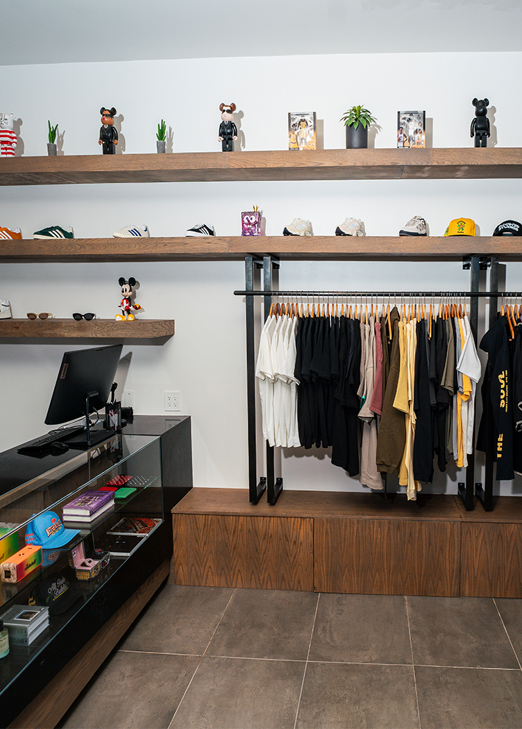 Streetwear boutique with men's shirts, sneakers, hats, and lifestyle collectibles on display.