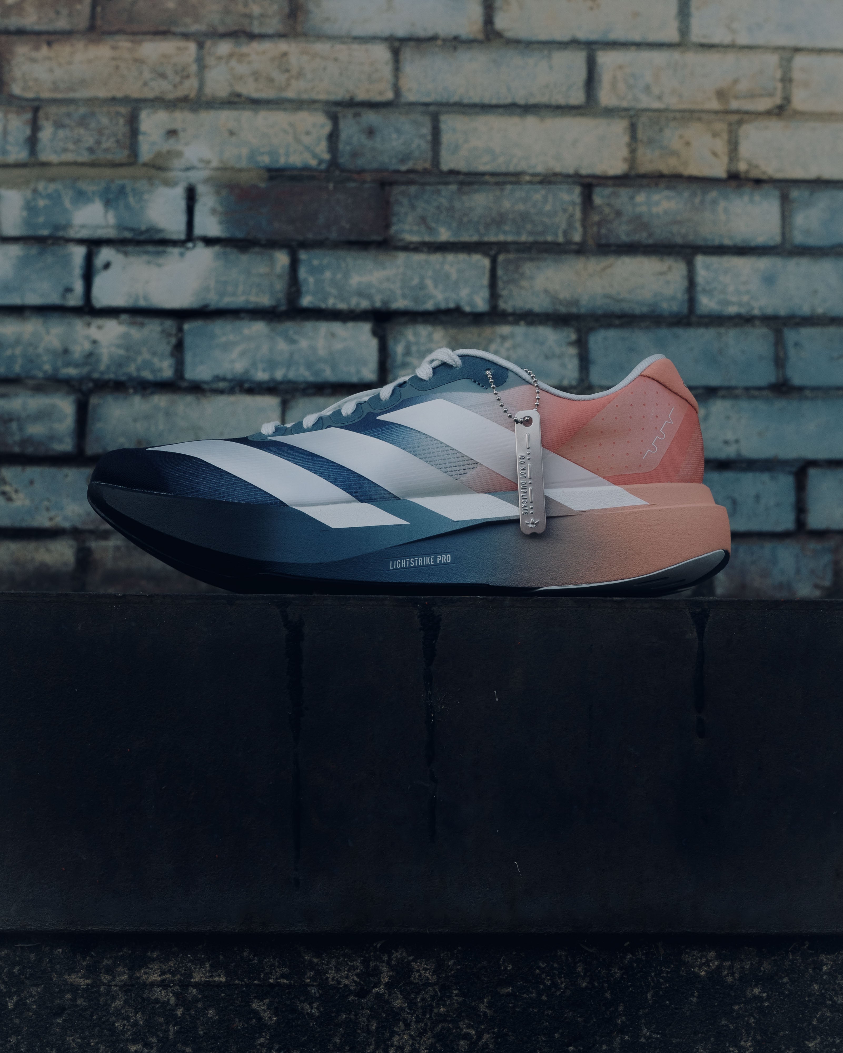 Stylish menβs streetwear sneaker with blue, white, and peach accents on urban brick background