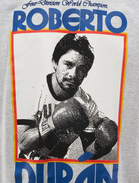 Graphic t-shirt featuring a pixelated boxer image and bold blue text on heather gray fabric.