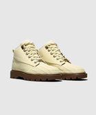 Beige lace-up boots with rugged brown soles on plain background