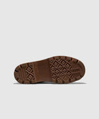 Brown rubber boot outsole with grippy tread pattern on a light background