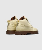Cream high-top casual boots with chunky brown soles, side and back view on gray background