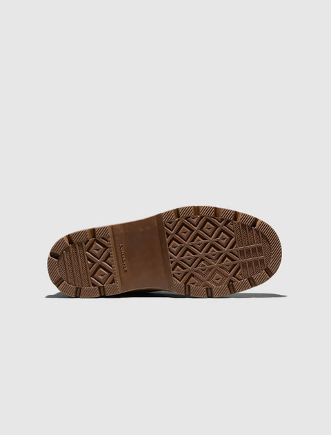 Brown rubber sneaker sole with textured tread pattern on a light background