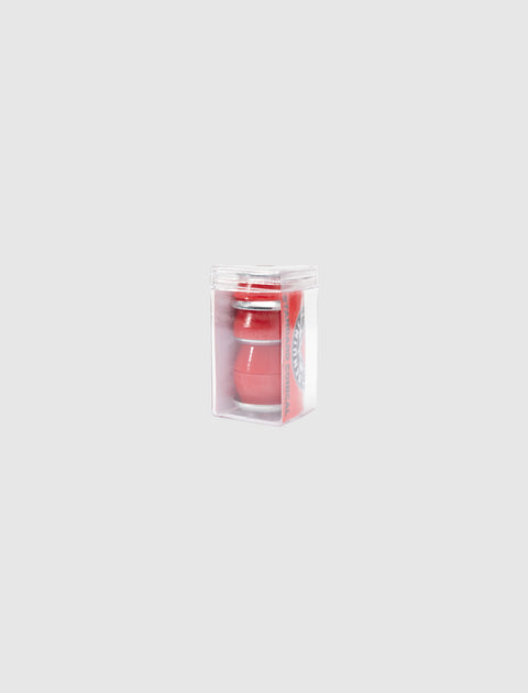 Red skateboard bushings in clear plastic packaging on a light gray background