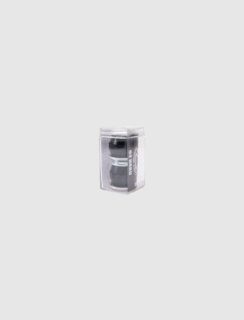 Black skateboard hardware in clear plastic packaging on a plain light background