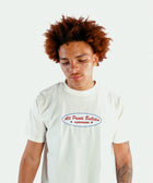 Model in white streetwear t-shirt with red blue logo text, casual men's apparel