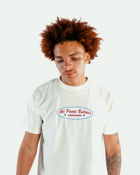 Model in white streetwear t-shirt with red blue logo text, casual men's apparel
