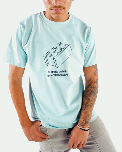 Man wearing light blue streetwear t-shirt with cinder block graphic and tattoo sleeve