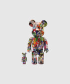 Two multicolor geometric art bear figurines with cartoon faces on a plain background.
