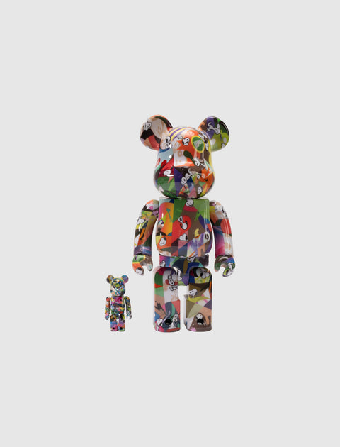 Two multicolor geometric art bear figurines with cartoon faces on a plain background.