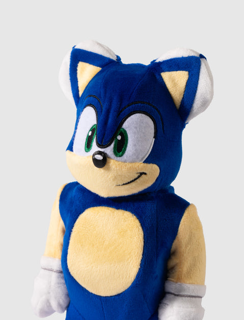 Blue plush toy with green eyes and white gloves, yellow details on chest and ears
