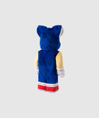 Blue and beige plush toy with red shoes and pointed ears, viewed from the back