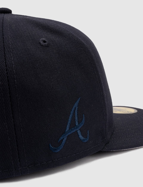 Close-up of a navy blue baseball cap with embroidered A logo on the side