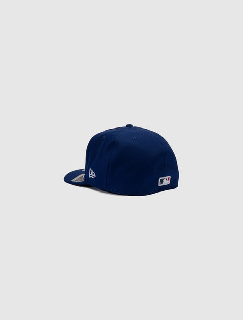 Navy blue fitted baseball cap with MLB logo, side and rear view on light background