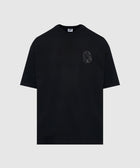 Black men's streetwear t-shirt with small astronaut graphic on chest, flat lay