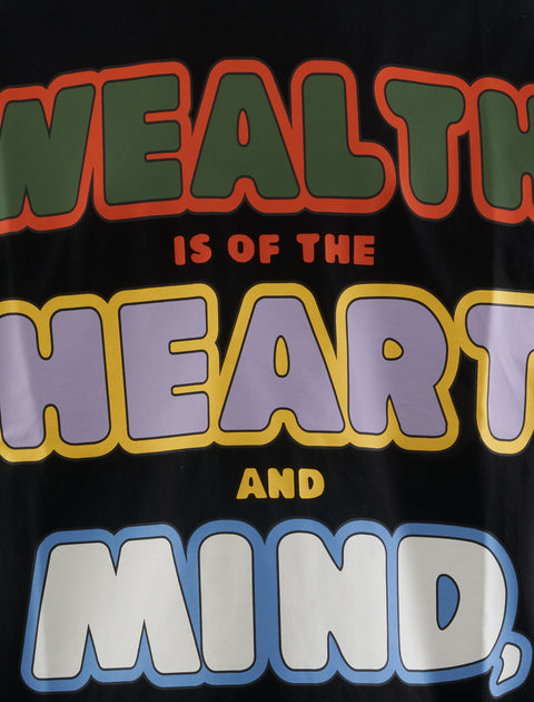 Streetwear t-shirt with colorful bold text reading 'Wealth is of the heart and mind' on black fabric