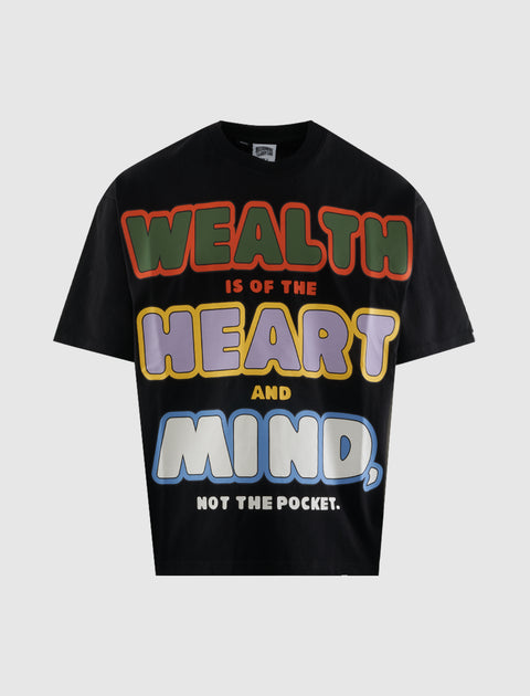Black streetwear t-shirt with bold colorful 'Wealth is of the heart and mind' graphic text.