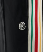 Black athletic pants with astronaut patch and green, red, yellow striped side panel