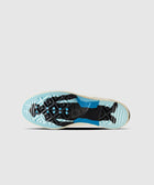 Outsole view of a sneaker featuring blue, black, and translucent tread patterns