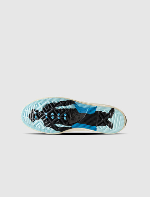 Outsole view of a sneaker featuring blue, black, and translucent tread patterns