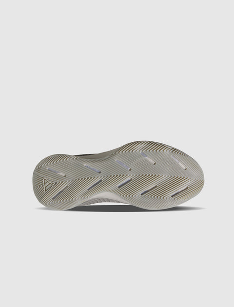 Grey sneaker outsole with herringbone tread pattern on white background