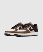 Brown and white low-top sneakers with black accents and perforated side panels on a light background.