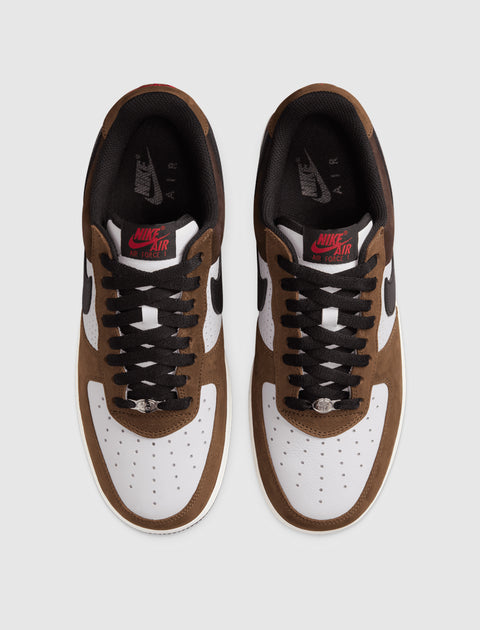 Top view of brown and white Nike Air Force 1 sneakers with black laces on white background