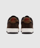 Rear view of brown Nike Air Force 1 Low sneakers with red logo and white sole on gray background