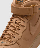Tan Nike Air Force 1 Mid sneaker with leather upper, strap, and green logo details