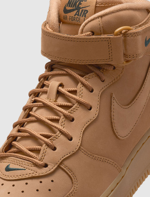 Tan Nike Air Force 1 Mid sneaker with leather upper, strap, and green logo details
