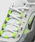 Close-up of white and grey sneaker with neon green lace accents and black Swoosh logo.