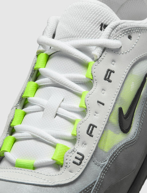 Close-up of white and grey sneaker with neon green lace accents and black Swoosh logo.