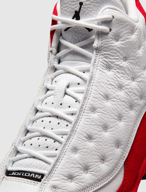 Close-up of white and red leather sneaker with perforated details and laces