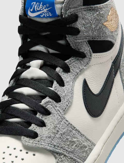 Close-up of a grey and white high top sneaker with black laces and blue Nike Air tongue tag