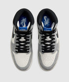 Top view of grey and white Nike Air sneakers with black laces on a light background