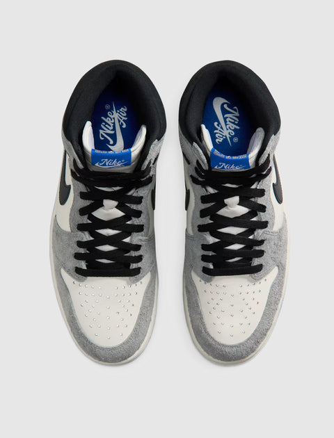 Top view of grey and white Nike Air sneakers with black laces on a light background