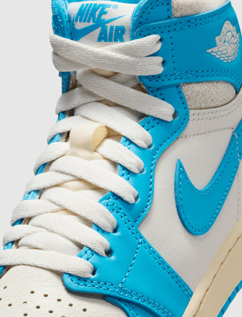 Close-up of white and blue high-top sneaker with white laces and Nike Air logo on tongue