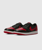 Black and red low-top sneakers with white midsoles, side view on plain background