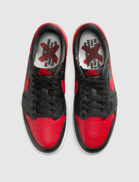 Black and red low-top sneakers with text graphic insoles, Nike swoosh logo visible