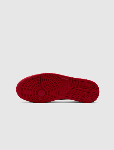 Red rubber sneaker outsole with concentric circle traction pattern on a light background