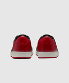 Back view of black and red low-top sneakers with white midsoles on a solid background
