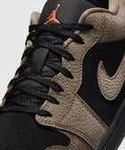 Close-up of black and olive low-top sneaker with textured leather and black laces