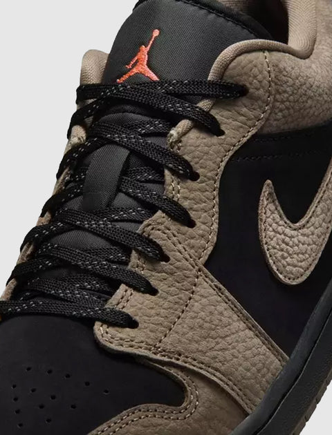 Close-up of black and olive low-top sneaker with textured leather and black laces