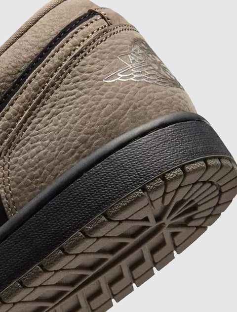 Close-up of brown and black sneaker heel with textured sole and stitched logo