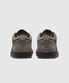 Back view of black and olive Air Jordan 1 Low sneakers on a light background.
