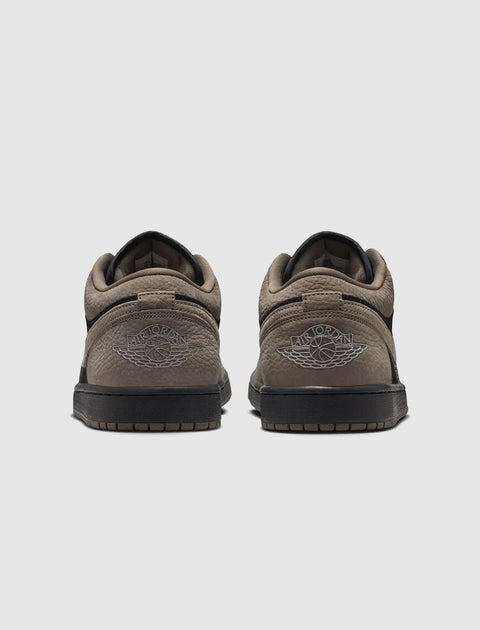 Back view of black and olive Air Jordan 1 Low sneakers on a light background.