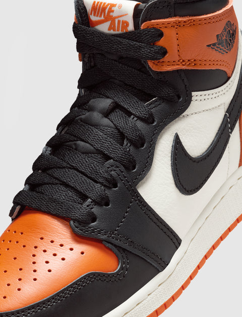 Close-up of Nike Air Jordan 1 sneaker in black, orange, and white leather