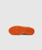Orange rubber outsole of a sneaker against a plain light background