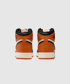 Rear view of orange, black, and white high-top sneakers on a light background.