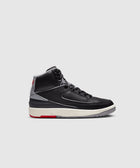 Black and grey high-top sneaker with red and ivory accents on a light background